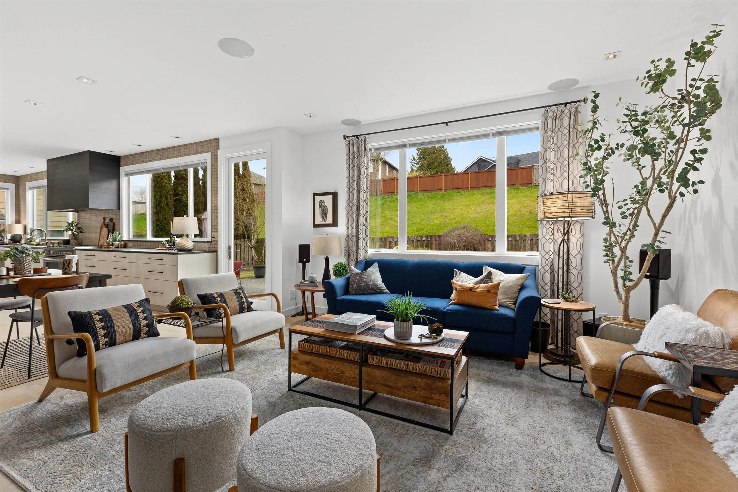 Cozy living room with a blue couch basking in the glow of a wide window.