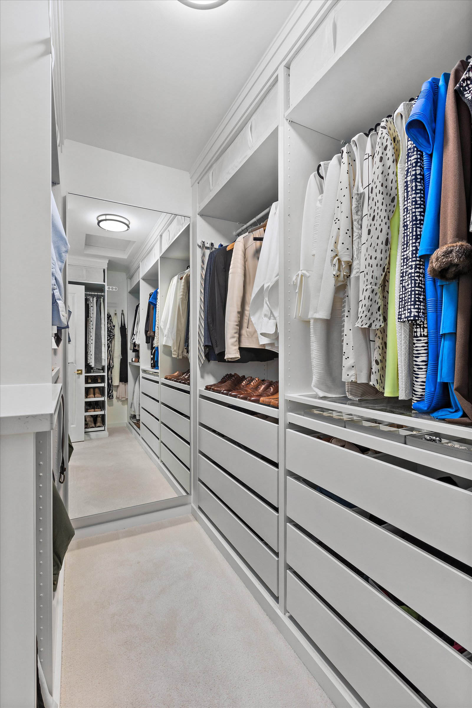 Spacious walk-in closet with white drawers