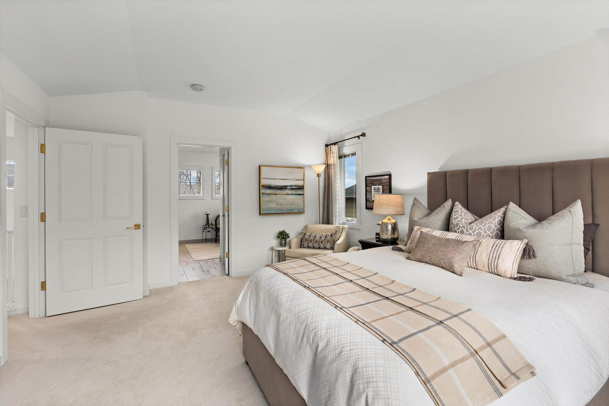 A tranquil white bedroom complete with a bed, dresser