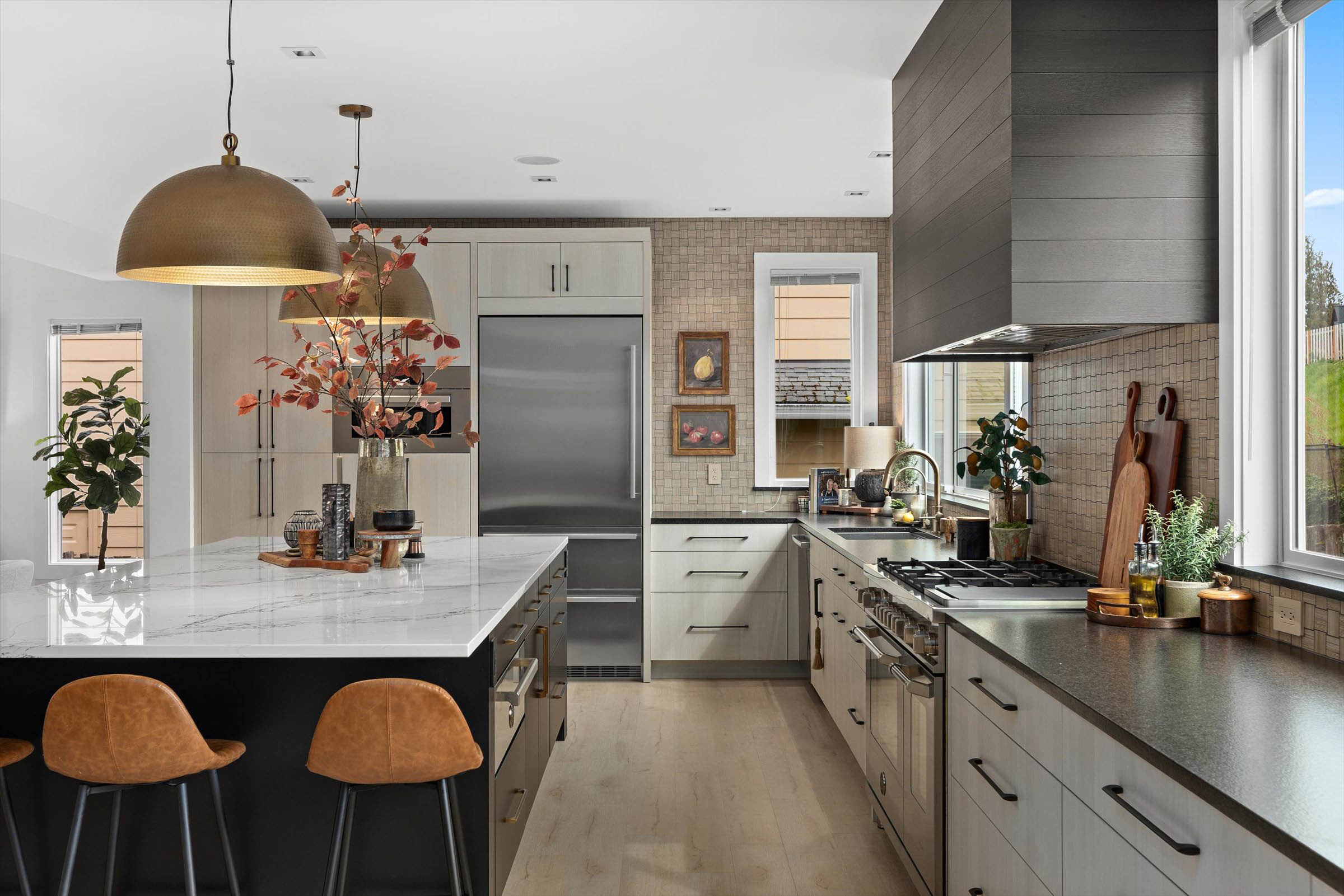 Bright kitchen with center island, large window, and white cabinets