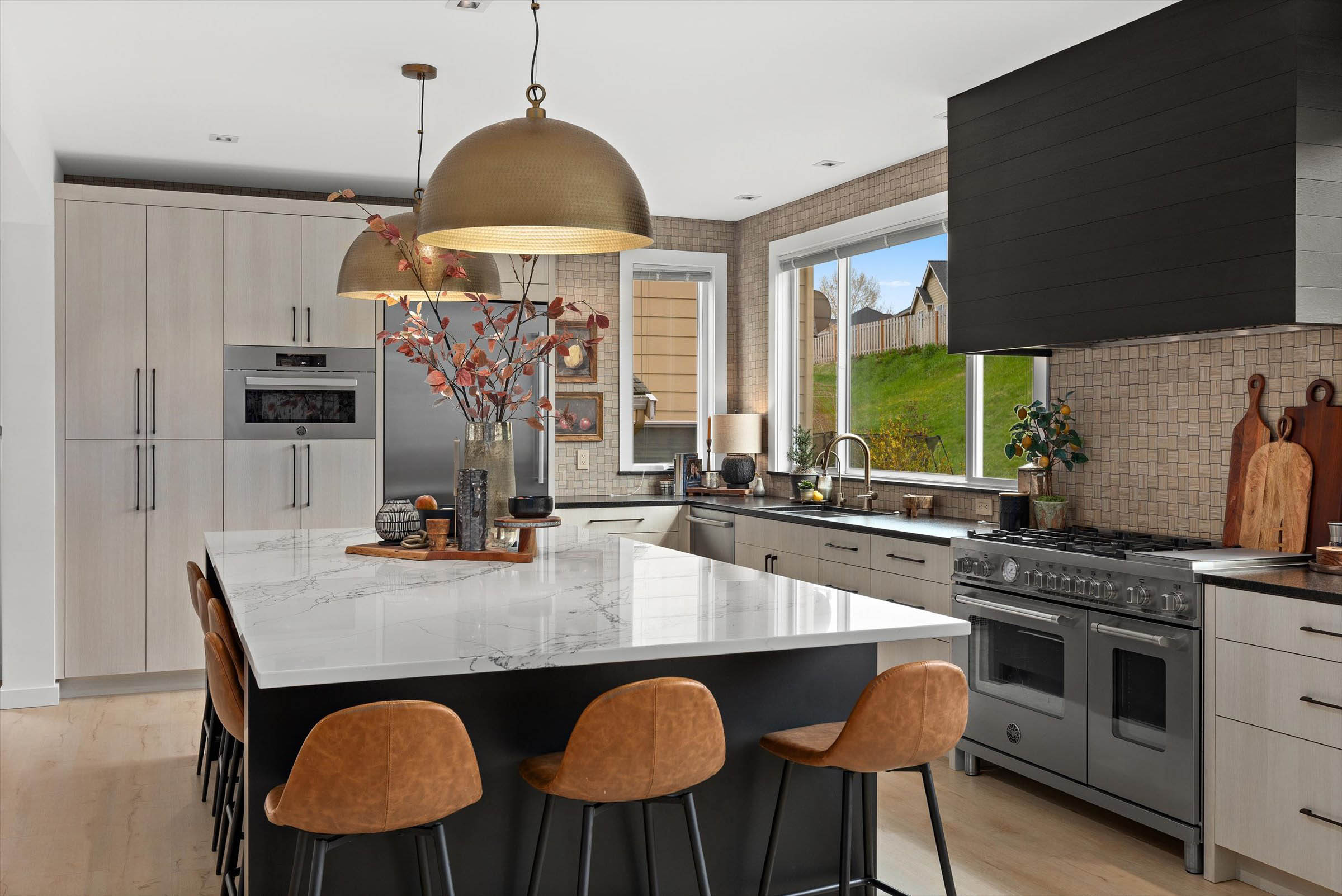 A kitchen with a spacious island and chairs. Perfect for kitchen remodeling services.